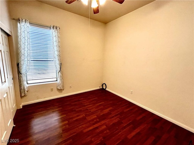 empty room with dark hardwood / wood-style flooring and ceiling fan