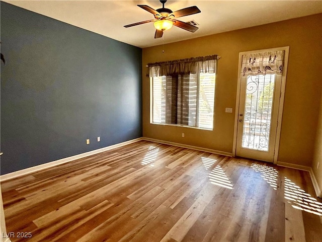 empty room with ceiling fan and light hardwood / wood-style floors