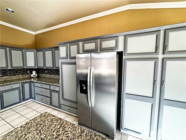 kitchen with gray cabinets, dark stone counters, ornamental molding, light tile patterned floors, and stainless steel refrigerator with ice dispenser