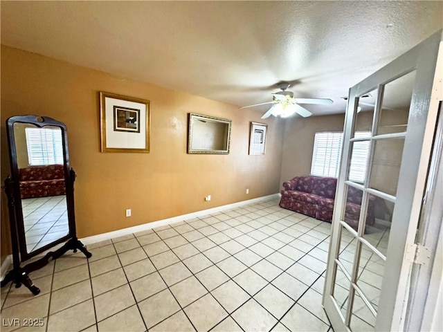 living area with light tile patterned floors, a textured ceiling, and ceiling fan