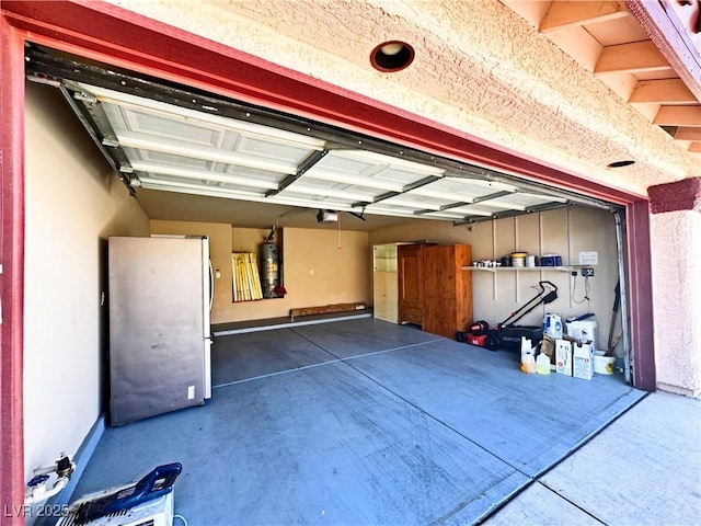 garage with a garage door opener, stainless steel fridge, and water heater