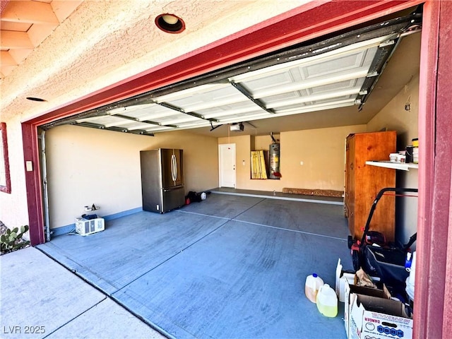 garage with a garage door opener, stainless steel fridge, and water heater