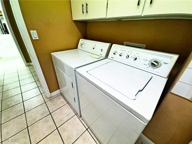 laundry room featuring cabinets, washer and clothes dryer, and light tile patterned floors