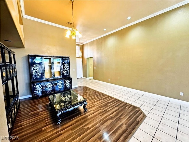 tiled living room featuring ornamental molding and a chandelier