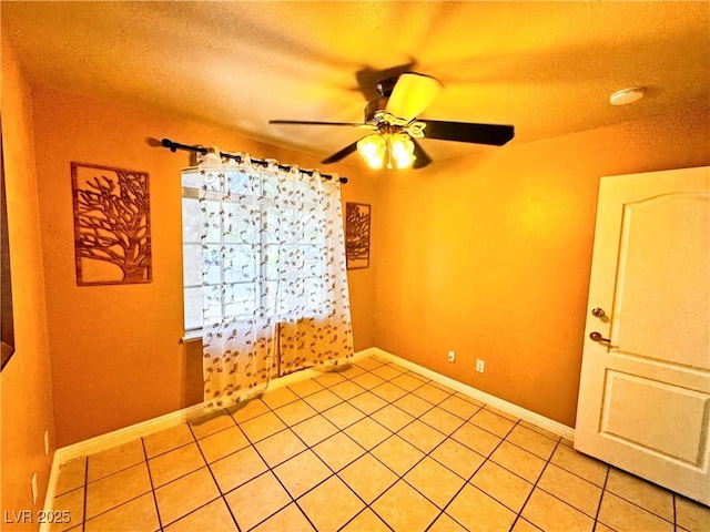 tiled empty room with a textured ceiling and ceiling fan