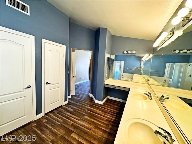 bathroom with vanity, an enclosed shower, hardwood / wood-style flooring, and vaulted ceiling