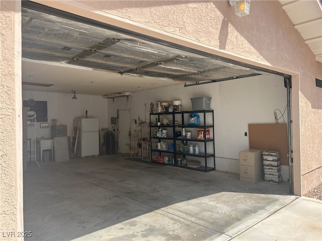 garage featuring a textured wall and freestanding refrigerator