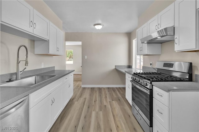 kitchen featuring stainless steel appliances, sink, light hardwood / wood-style flooring, and white cabinets