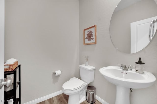 bathroom with wood-type flooring, sink, and toilet