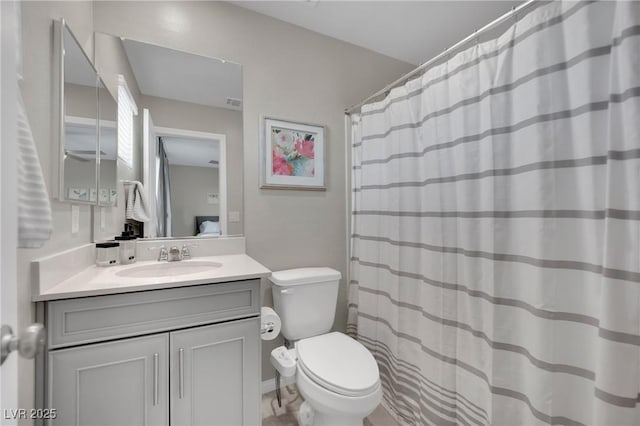 bathroom featuring walk in shower, vanity, and toilet