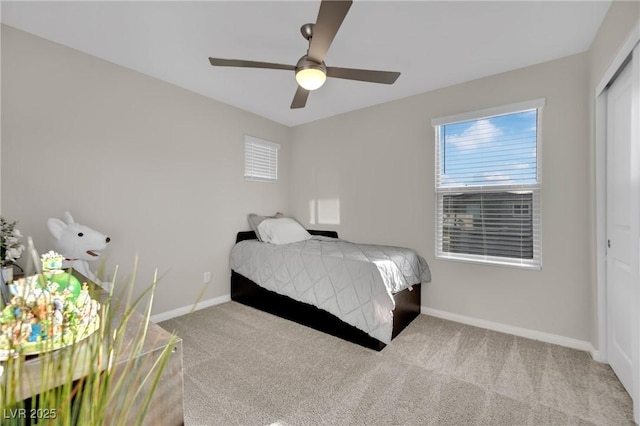 bedroom with light colored carpet, ceiling fan, and a closet