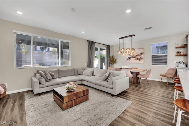 living room featuring an inviting chandelier and light wood-type flooring