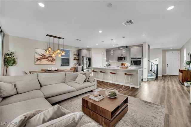 living room featuring an inviting chandelier and hardwood / wood-style floors