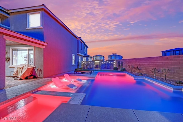 pool at dusk featuring a patio area