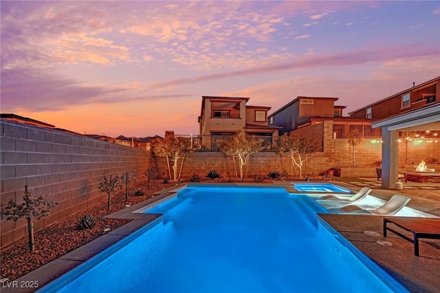 pool at dusk with a fire pit