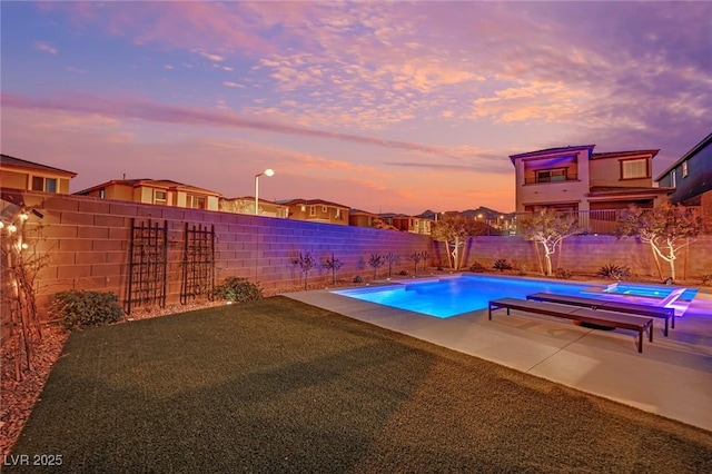 pool at dusk featuring a patio area