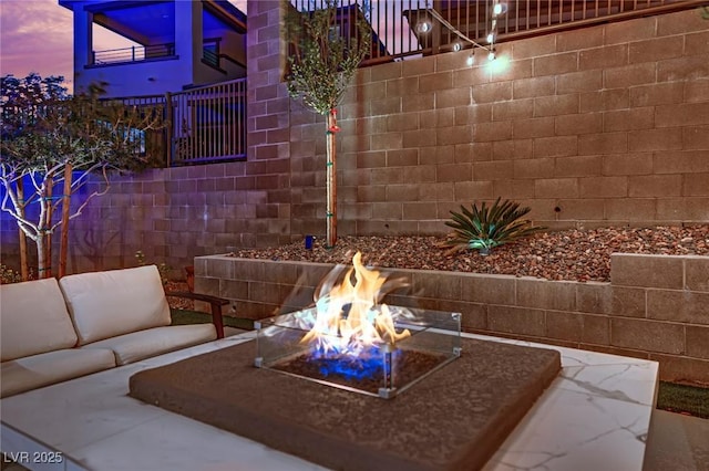 patio terrace at dusk featuring an outdoor living space with a fire pit