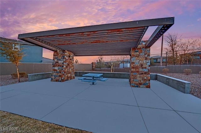 patio terrace at dusk featuring a pergola