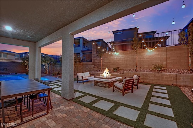 patio terrace at dusk featuring an outdoor fire pit