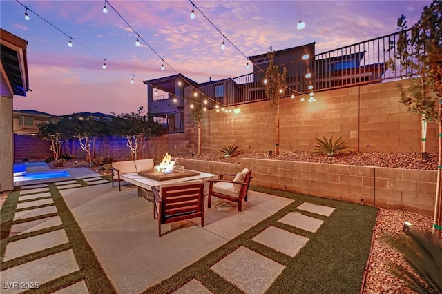 patio terrace at dusk featuring an outdoor fire pit