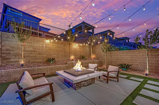 patio terrace at dusk featuring an outdoor fire pit