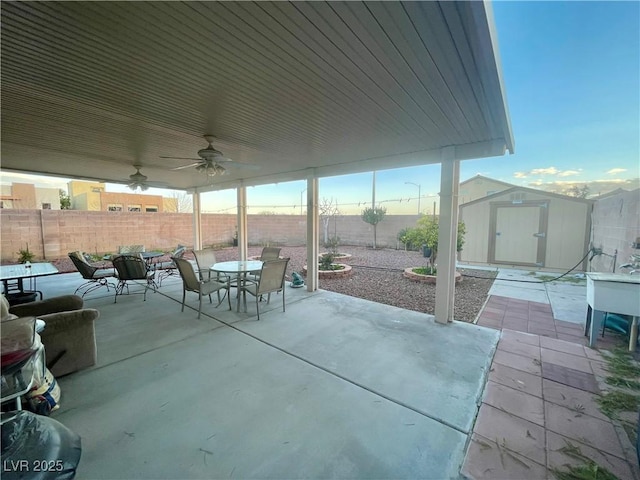 view of patio with ceiling fan and a storage shed