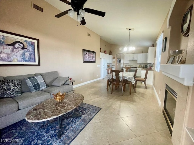 living room with ceiling fan with notable chandelier and light tile patterned floors