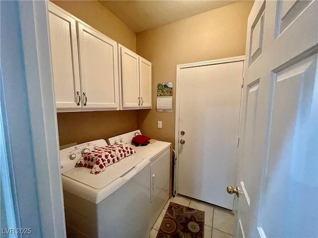 laundry room with cabinets, washing machine and dryer, and light tile patterned floors