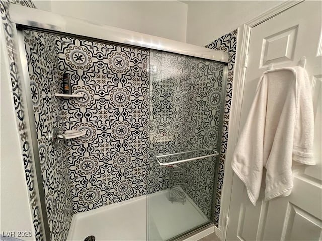 bathroom with a shower with door