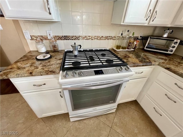 kitchen with tasteful backsplash, stainless steel range with gas cooktop, and white cabinets