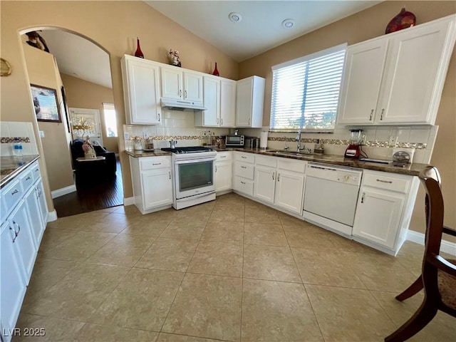 kitchen featuring vaulted ceiling, sink, white cabinets, and white appliances