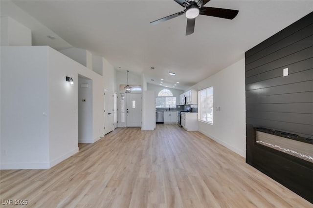 unfurnished living room featuring ceiling fan, lofted ceiling, and light wood-type flooring