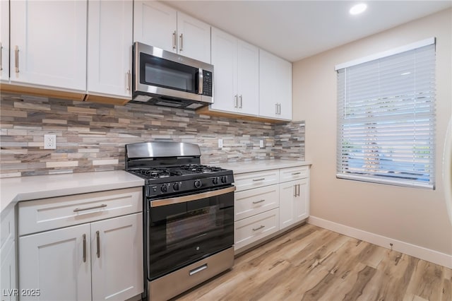 kitchen featuring white cabinetry, gas stove, decorative backsplash, and light hardwood / wood-style flooring