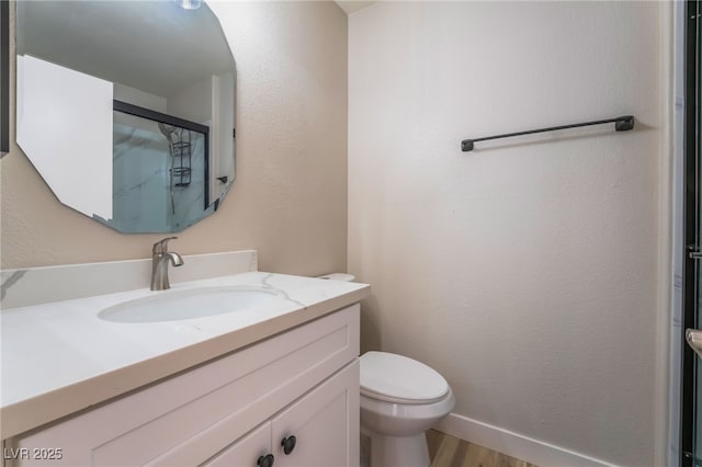 bathroom with vanity, hardwood / wood-style floors, and toilet