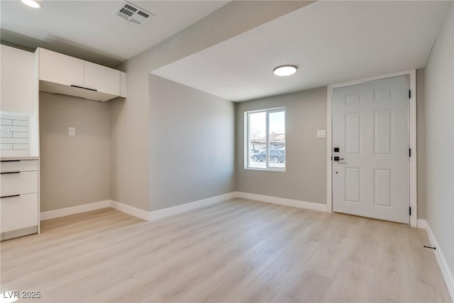 interior space with white cabinetry and light hardwood / wood-style flooring