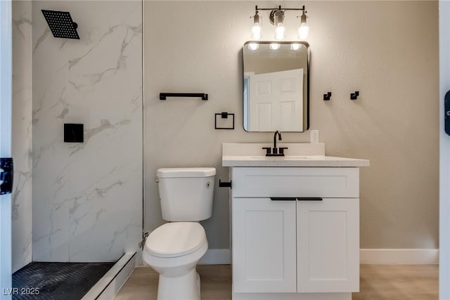 bathroom featuring vanity, toilet, hardwood / wood-style floors, and a tile shower