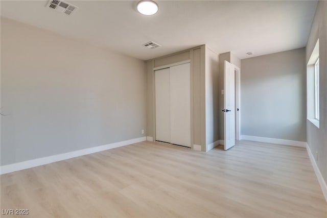 unfurnished bedroom with light hardwood / wood-style floors and a closet