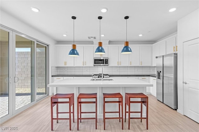 kitchen with white cabinets, visible vents, backsplash, and appliances with stainless steel finishes