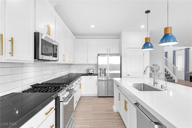 kitchen featuring white cabinetry, a sink, backsplash, and appliances with stainless steel finishes
