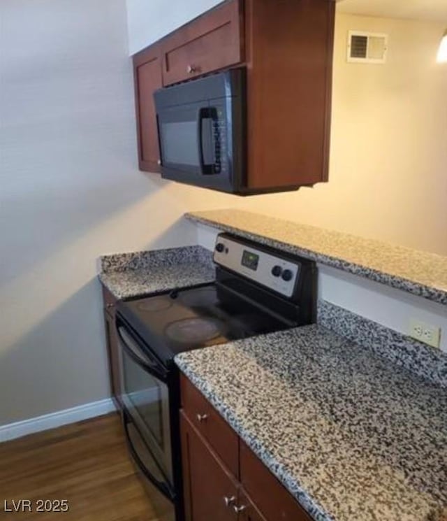 kitchen with light stone counters, dark hardwood / wood-style floors, and stainless steel electric range