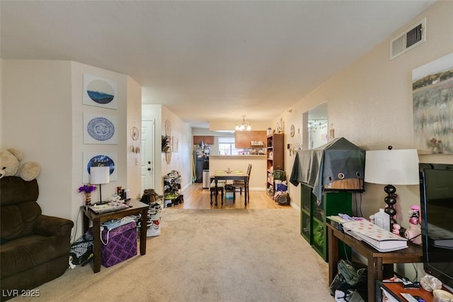 carpeted living room featuring a notable chandelier