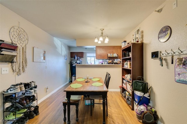 dining area with a chandelier and light wood-type flooring