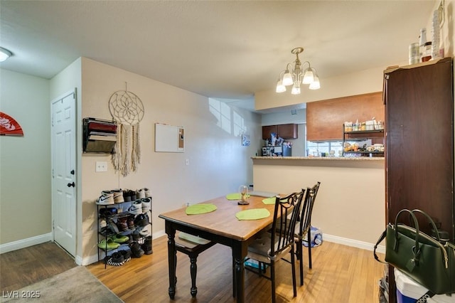 dining room with light hardwood / wood-style floors and a notable chandelier