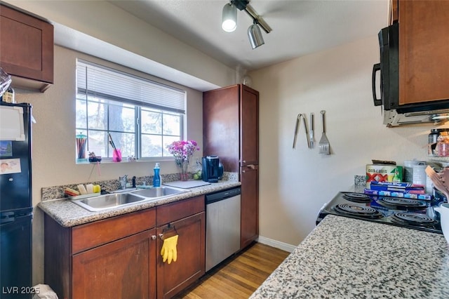 kitchen with dishwasher, sink, range, and light wood-type flooring