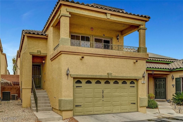 mediterranean / spanish-style house with cooling unit, a balcony, an attached garage, and stucco siding