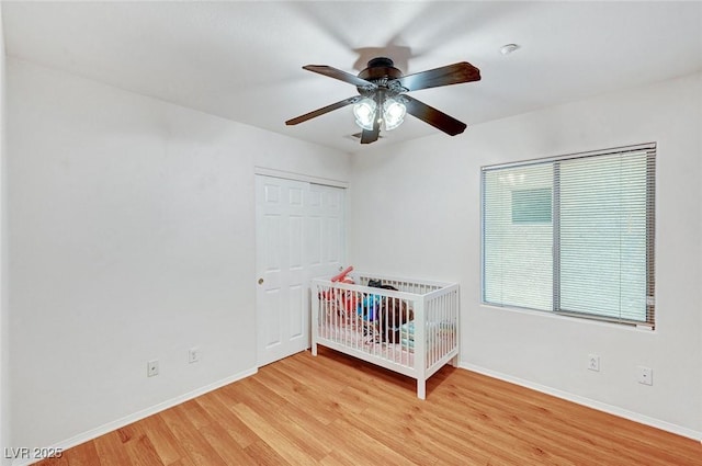 unfurnished bedroom featuring ceiling fan, light hardwood / wood-style floors, and a closet