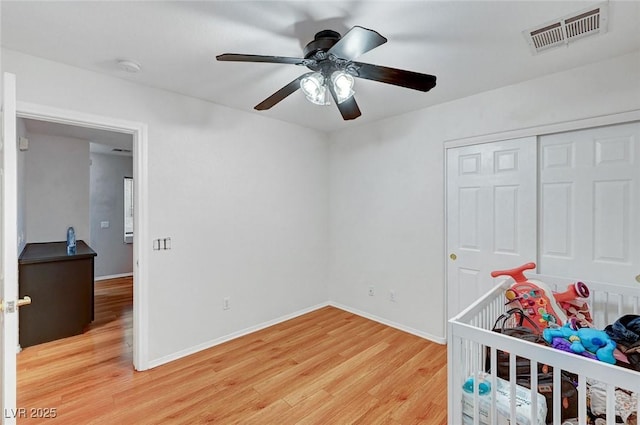 bedroom featuring hardwood / wood-style flooring, ceiling fan, and a closet