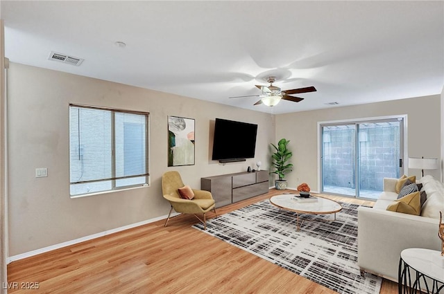 living room with ceiling fan and light hardwood / wood-style flooring