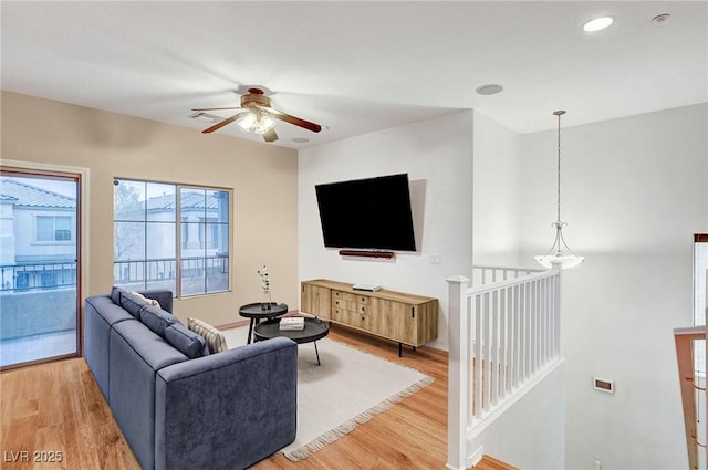 living room featuring ceiling fan and hardwood / wood-style floors