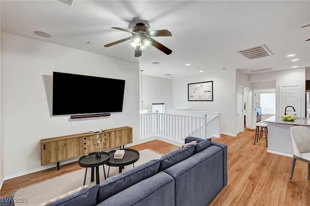 living room with ceiling fan and light wood-type flooring